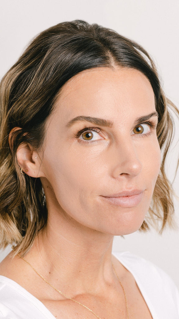 Short hair, brunette professional working woman with a partial smile looking at the camer